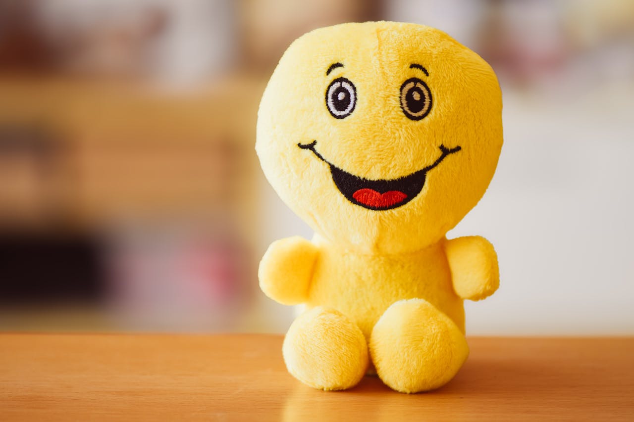 Bright yellow plush toy with happy face, perfect for adding joy to any setting.