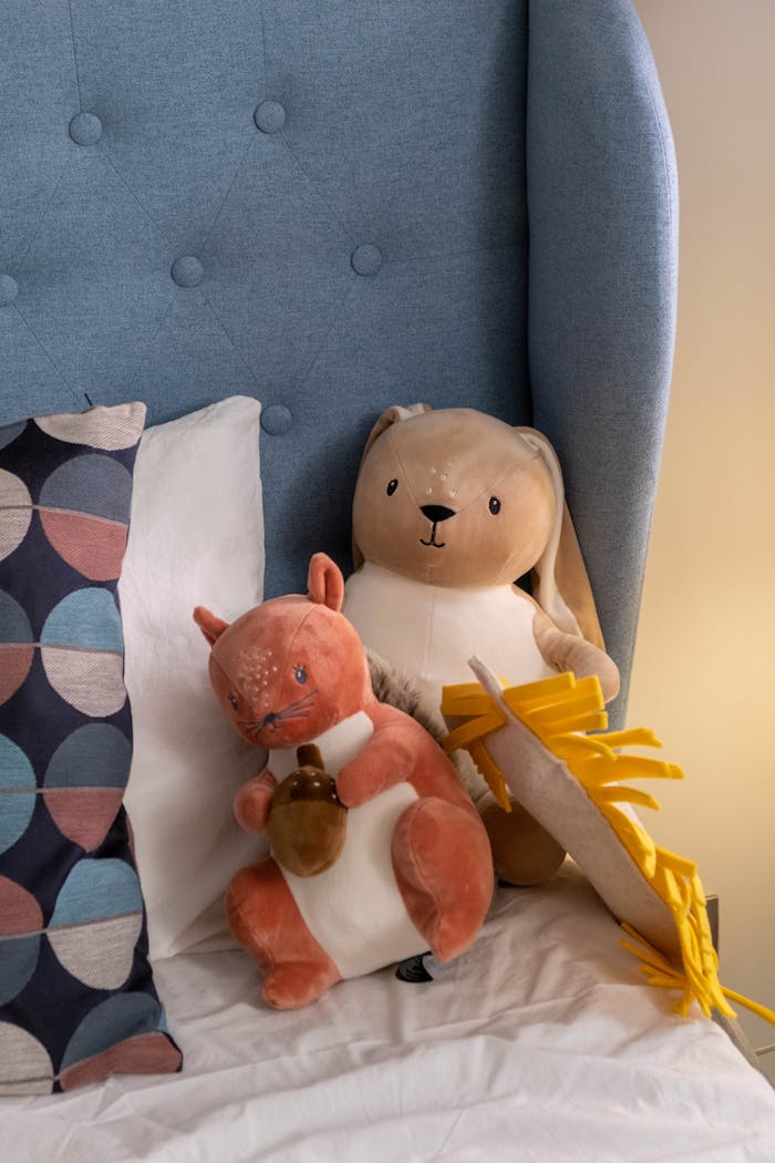 A warm and inviting arrangement of plush toys on a bed, ideal for children's room decor.
